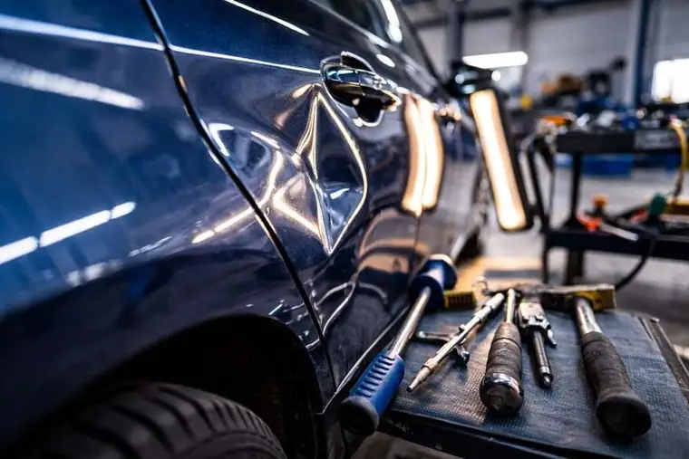 Dent repair Houston panel with visible dent and repair tools