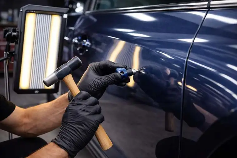 Paintless dent repair Houston technician using PDR tools on door panel